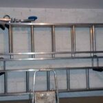 Ladder brackets fix to the wall with chemical fixing shown in use with ladders stored