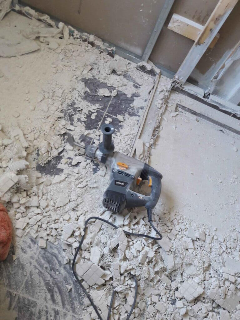 Using SDS breaker with chisel bit to pull up 2 layers of old floor tiles