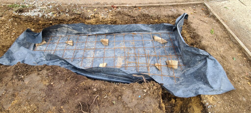 Concrete reinforcing mesh placed over bricks for height on plastic sheet ready to pour concrete