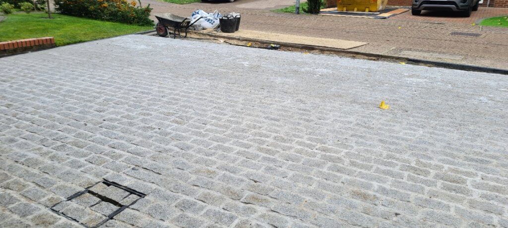 Driveway nearly fully cobbled setts in inspection cover frame yet to be grouted 1