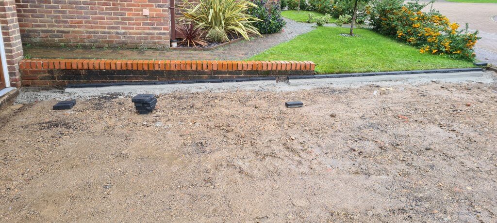 Entire site levelled and edging brick set in sharpsand and cement haunching