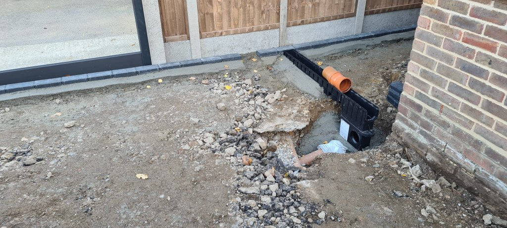 First part of channel drain and sump levelled up and set in cement haunching ready to be connected to soakaway pipe