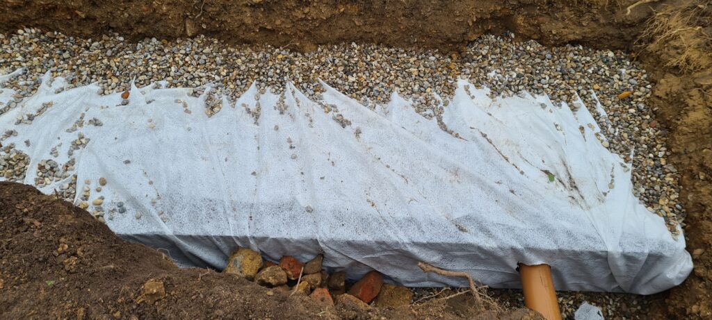 Gravel lining the soak away pit and covering terram