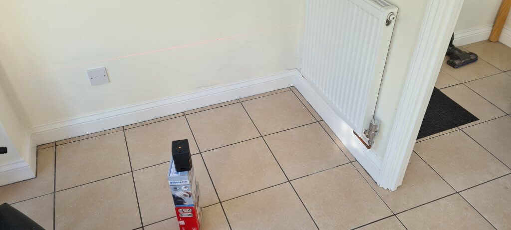 Using a laser level to mark the seat height of the bench on the wall