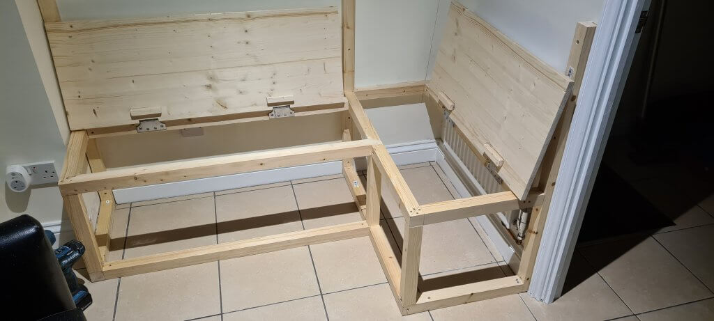 The knotty pine bench seat lids screwed into position on the frame
